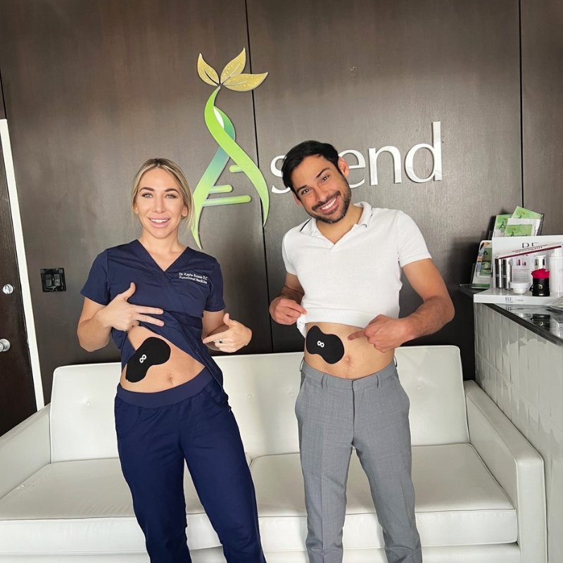 Two people showing abdominal patches in a clinic setting.