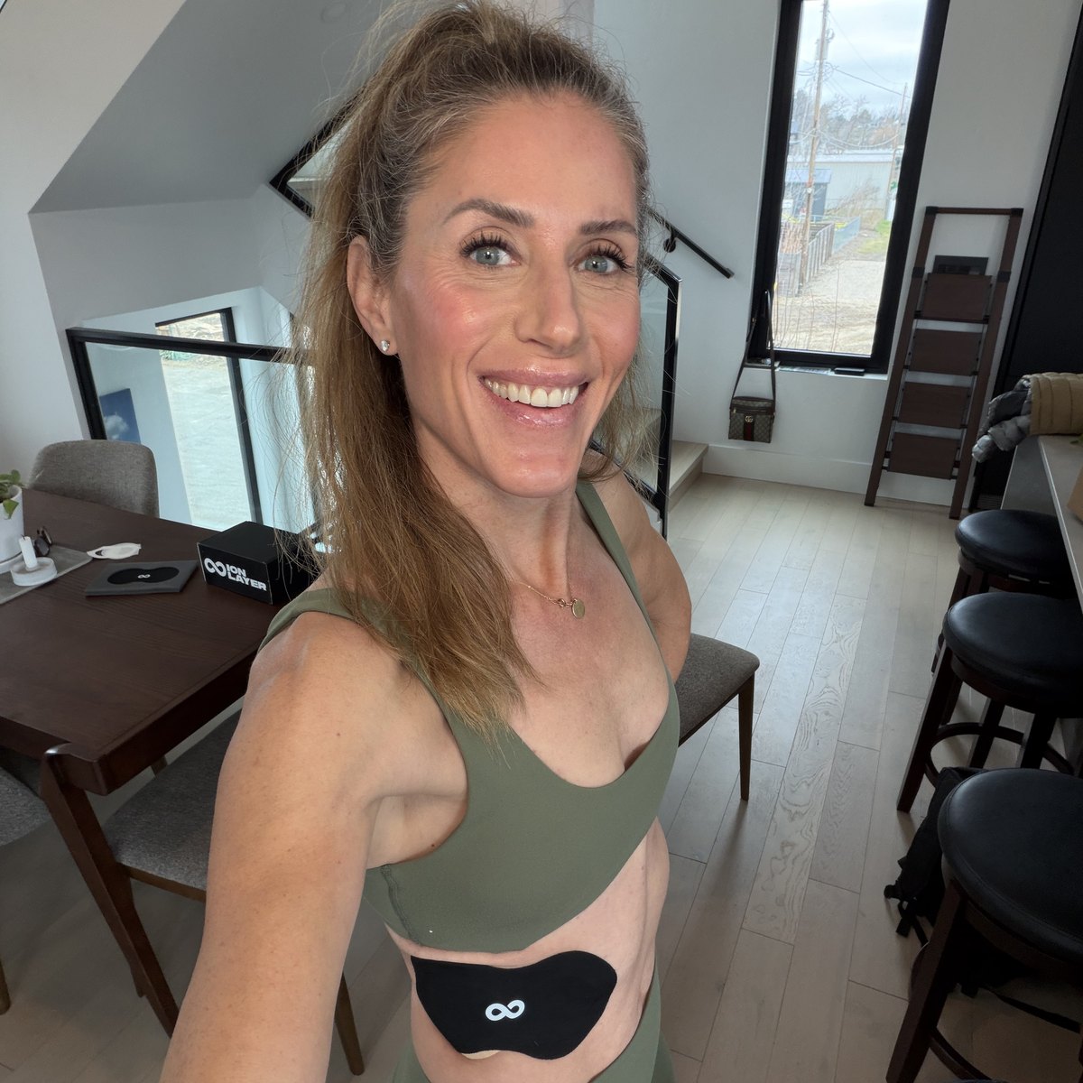 Woman wearing an Ion Layer NAD+ patch on her abdomen at home